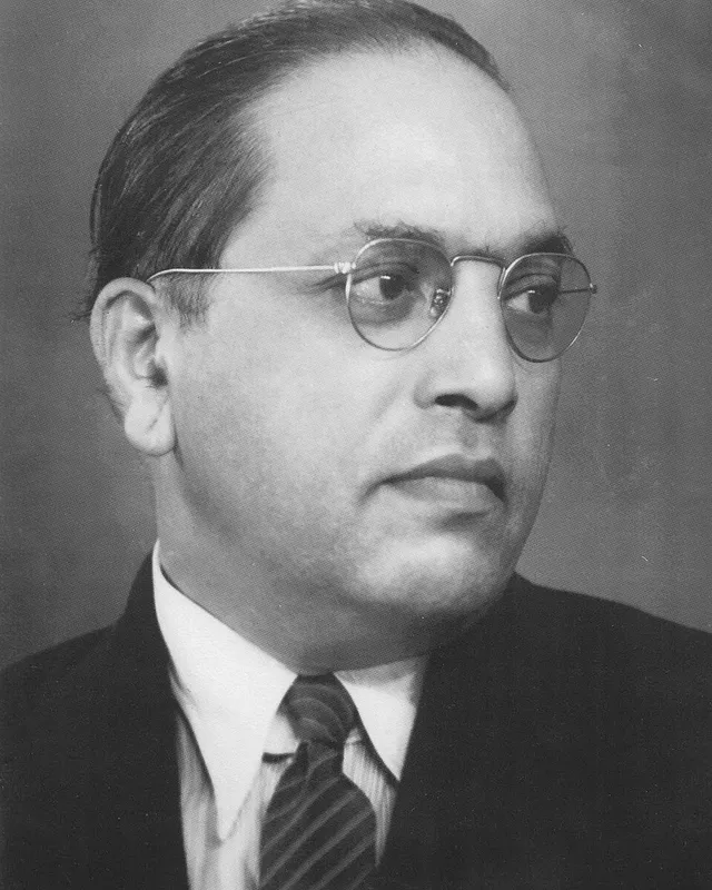 Photographic portrait of B. R. Ambedkar in a suit and tie, wearing round glasses.