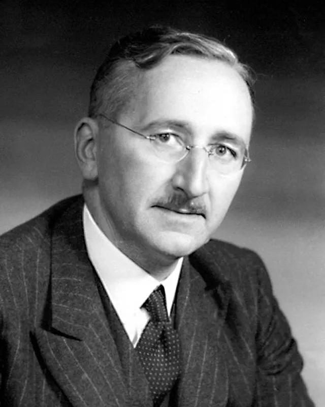 Photographic portrait of Friedrich Hayek in later life, wearing glasses and a suit.