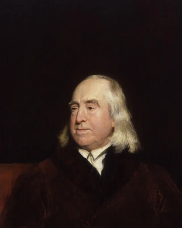 Painted portrait of Jeremy Bentham seated at a desk.