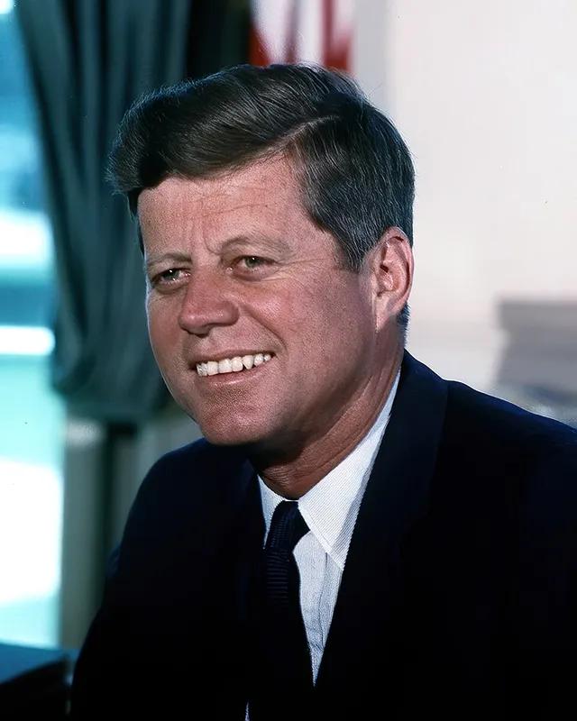 Colour White House portrait photograph of John F. Kennedy.
