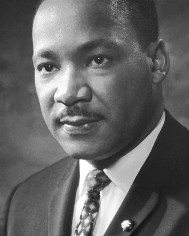 Photographic portrait of Martin Luther King Jr. in a dark suit and tie.