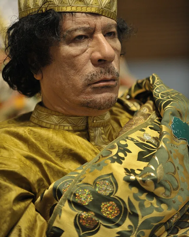 Photograph of Muammar Gaddafi in patterned robes at an African Union summit.