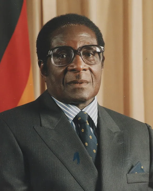 Official portrait of Robert Mugabe in a suit and glasses.