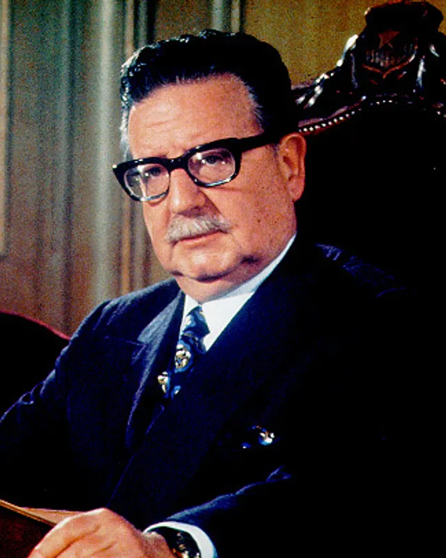 Photograph of Salvador Allende in a suit and glasses.